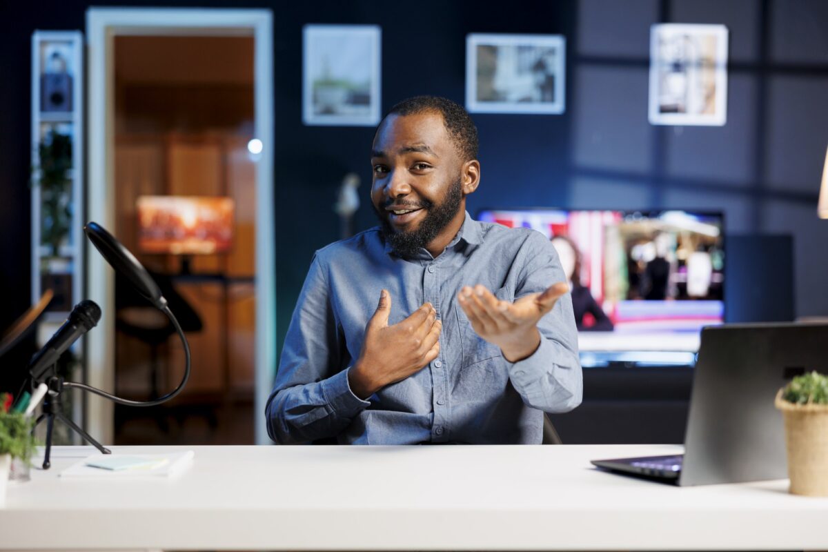 Créateur de contenu afro-américain réalisant des vidéos de type recommandations de voyage pour les fans, filmant dans son appartement.