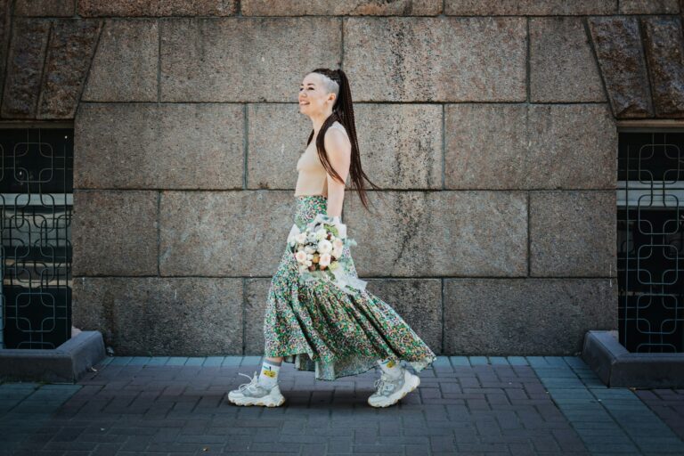 Mariée hipster moderne et contemporaine en robe informelle et baskets avec bouquet de fleurs de mariée comestibles. 