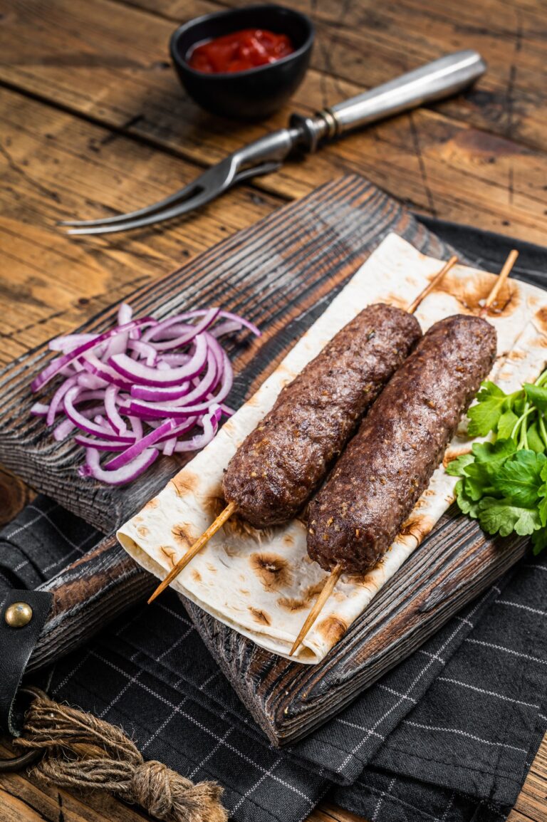 Kefta traditionnel du Moyen-Orient, kofta kebab à base de bœuf haché et de viande d'agneau grillée sur des brochettes servies avec du pain plat et de l'oignon. 