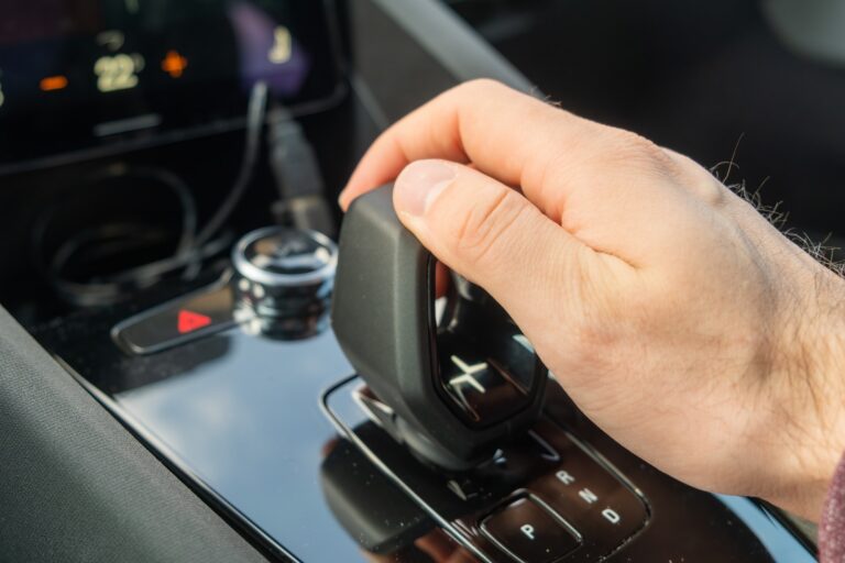 PRAGUE , RÉPUBLIQUE TCHÈQUE - 10 MARS 2022 : L'homme change de mode sur la transmission automatique de la nouvelle voiture électrique Polestar 2. Automobile moderne de luxe avec un design intérieur élégant en gros plan