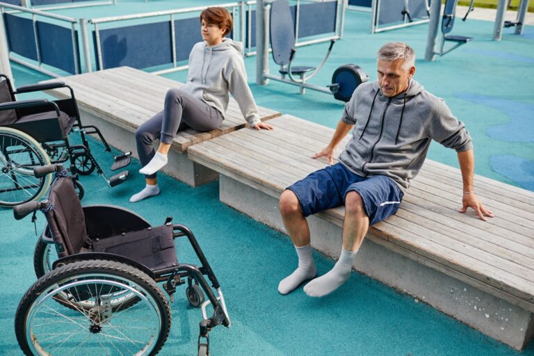 Deux patients assis sur le banc à l'extérieur se reposent après des exercices sportifs, ils récupèrent avec le sport