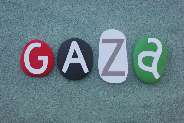 Gaza ou ville de Gaza, ville palestinienne de la bande de Gaza et la plus grande ville de l'État de Palestine, texte créatif composé des couleurs du drapeau national sur quatre pierres sur fond de sable vert