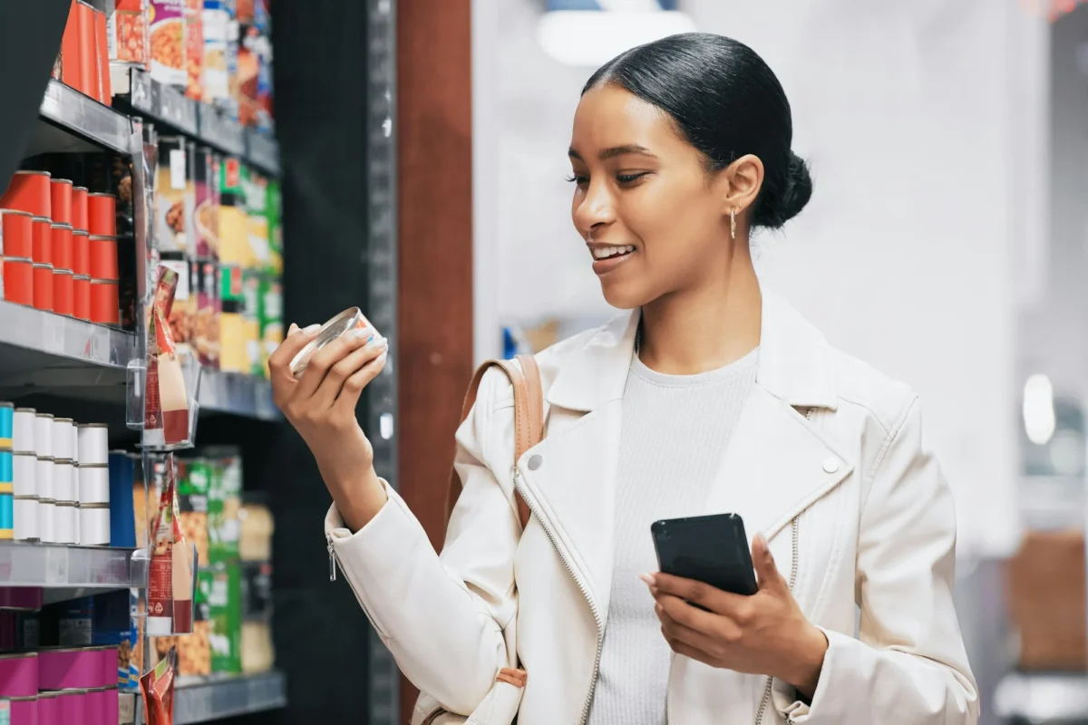 Supermarché, shopping et client avec smartphone vérifient le prix, l'étiquette ou les informations sur le produit en ligne.
