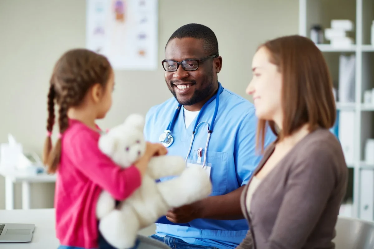 Médecin souriant examinant son petit patient